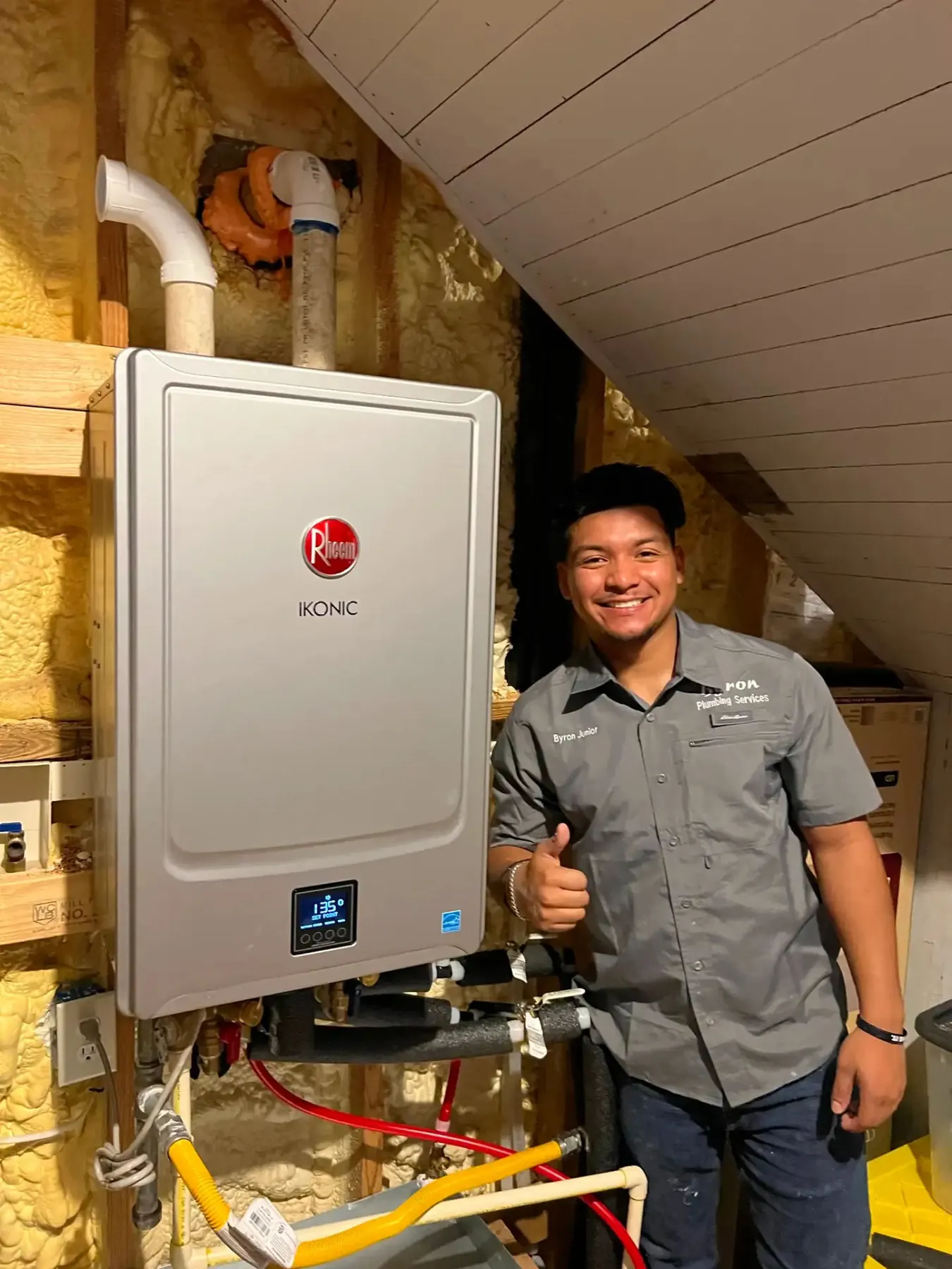 Rheem tankless water heater installed in an insulated attic.