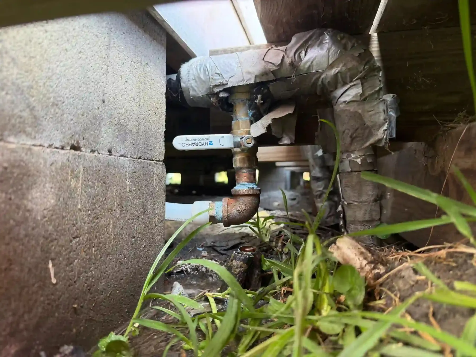 Underground water valve in a residential lawn, exposed for plumbing work.