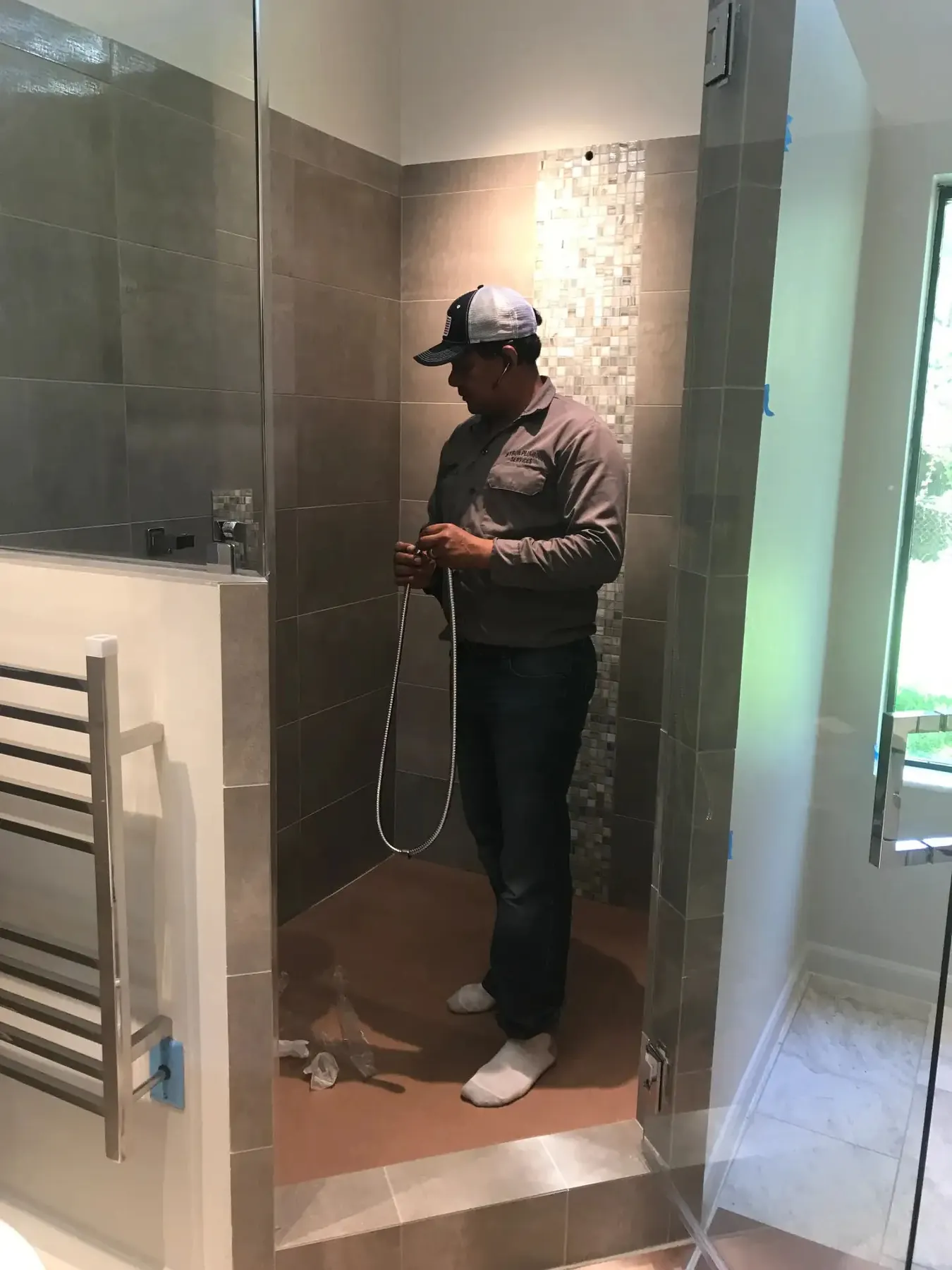 Shower fixture installation in a tiled bathroom.