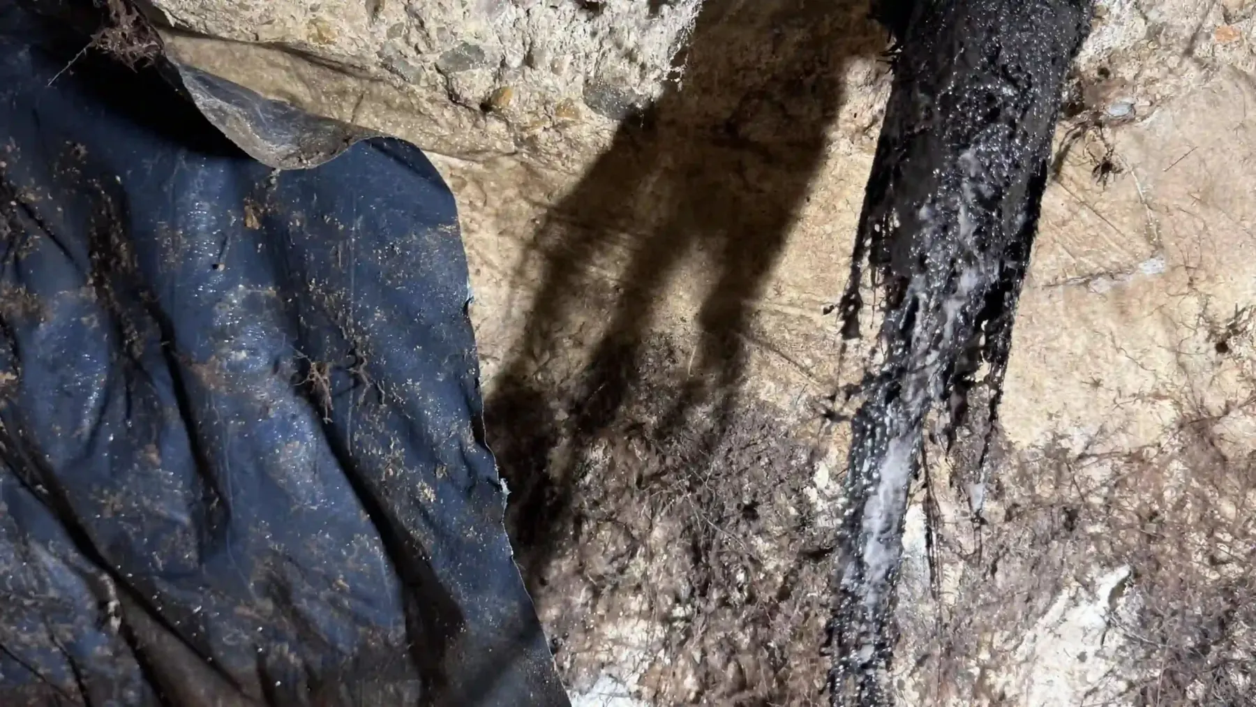 Underground excavation opened to reach and repair plumbing pipework.
