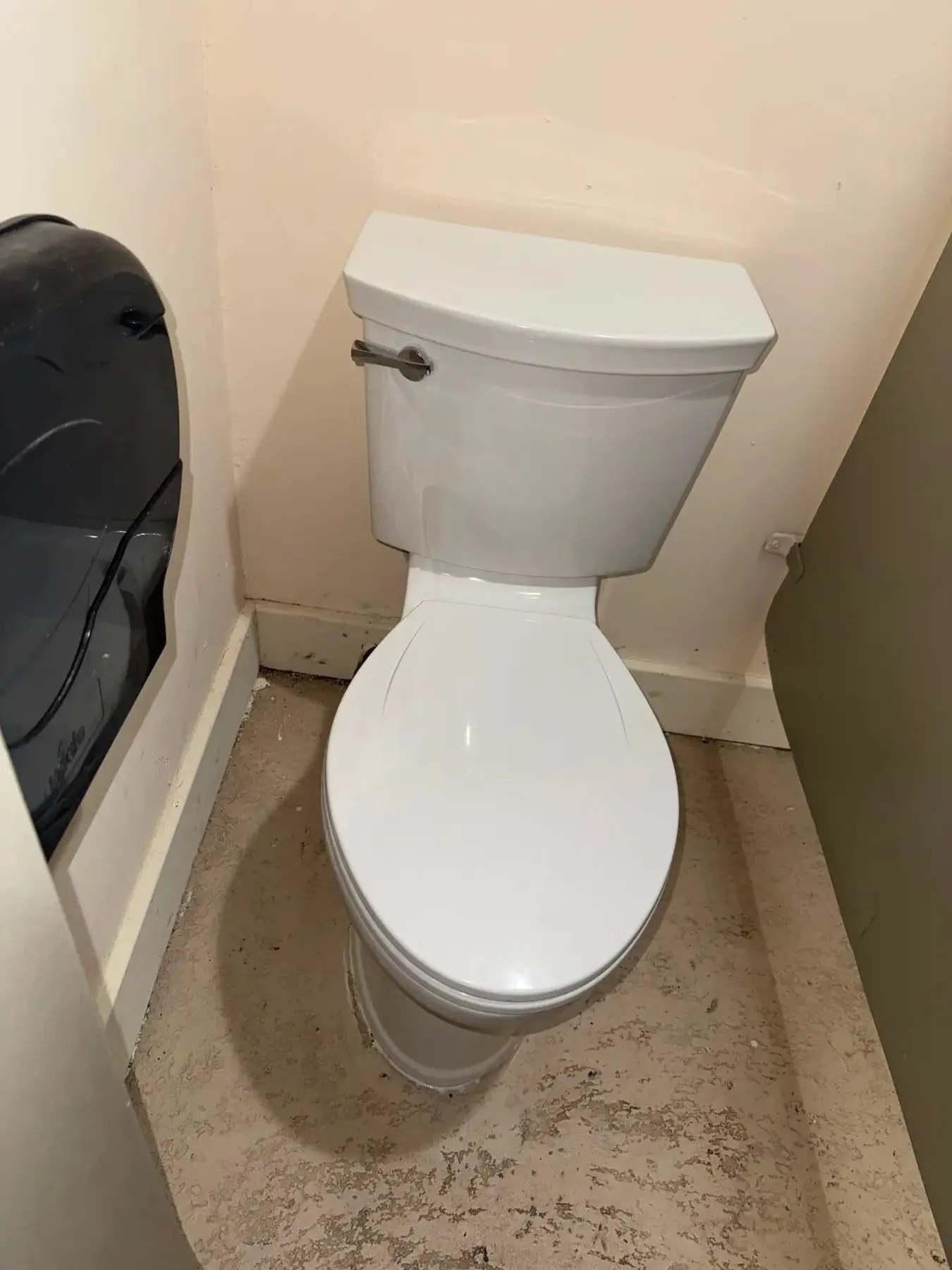 Modern white toilet installed in a bright bathroom.