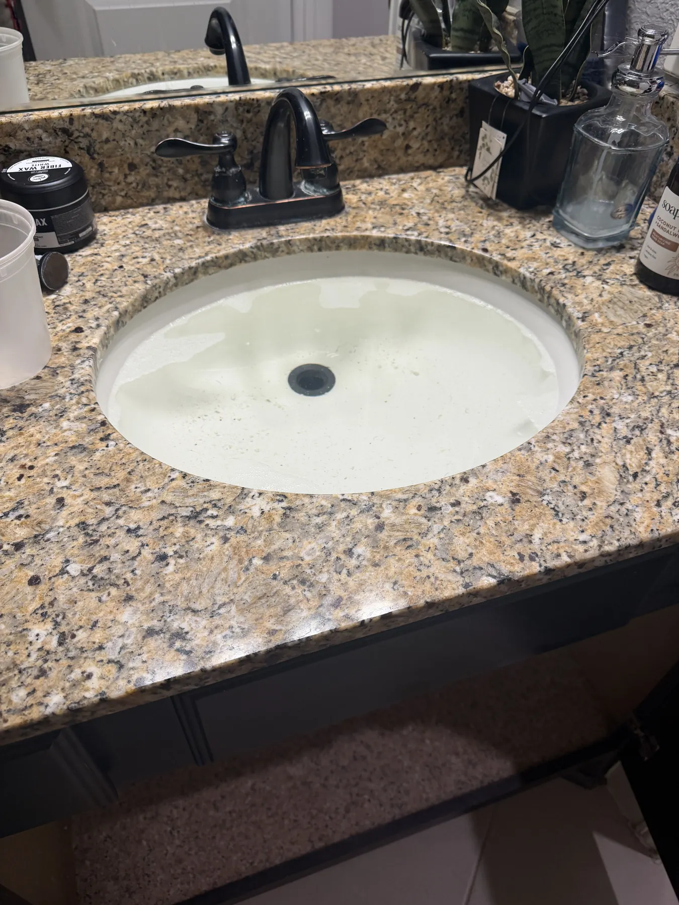 Leaky sink drain and P-trap repaired beneath a bathroom sink.